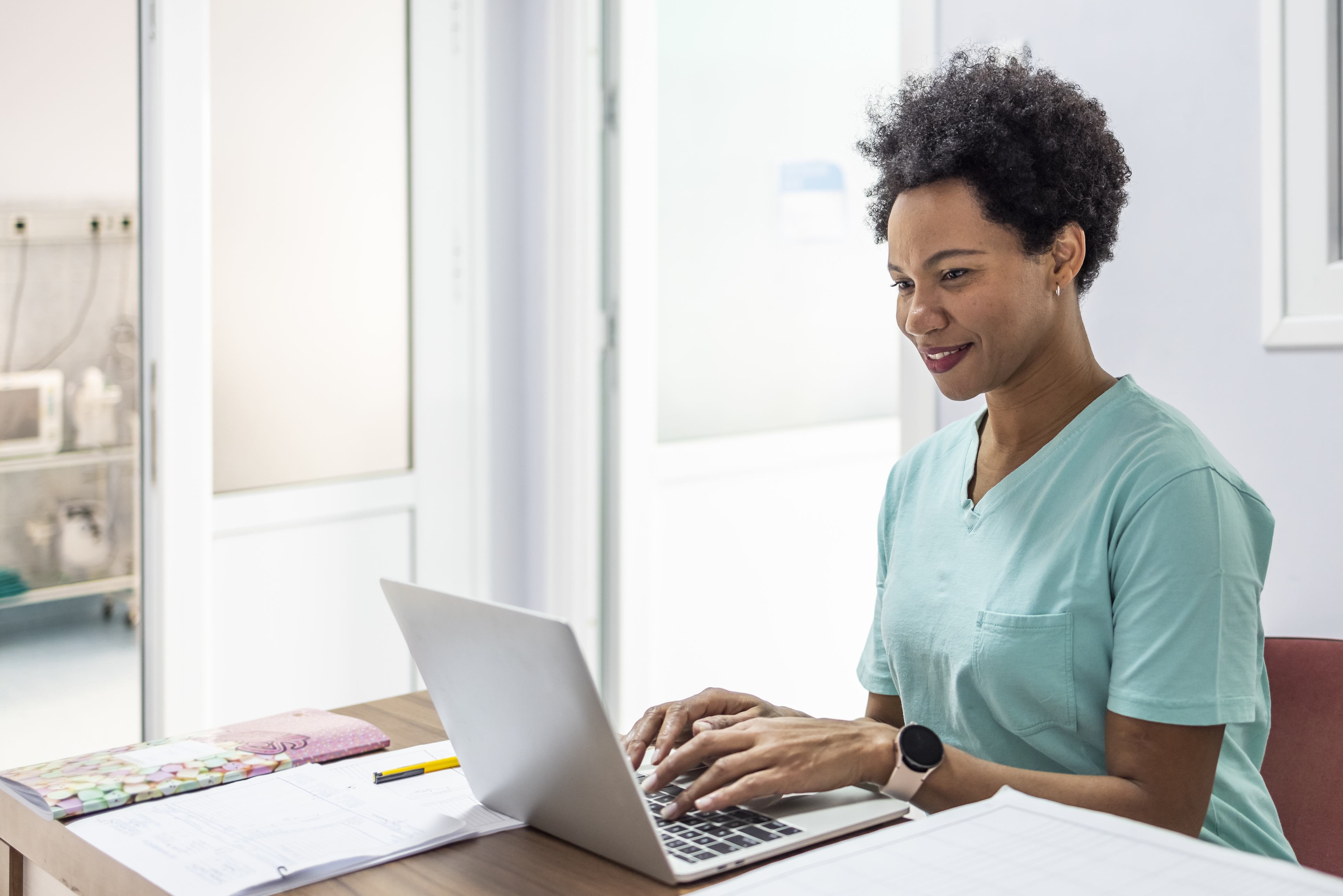 Un professionnel de la santé tapant sur un ordinateur portable.