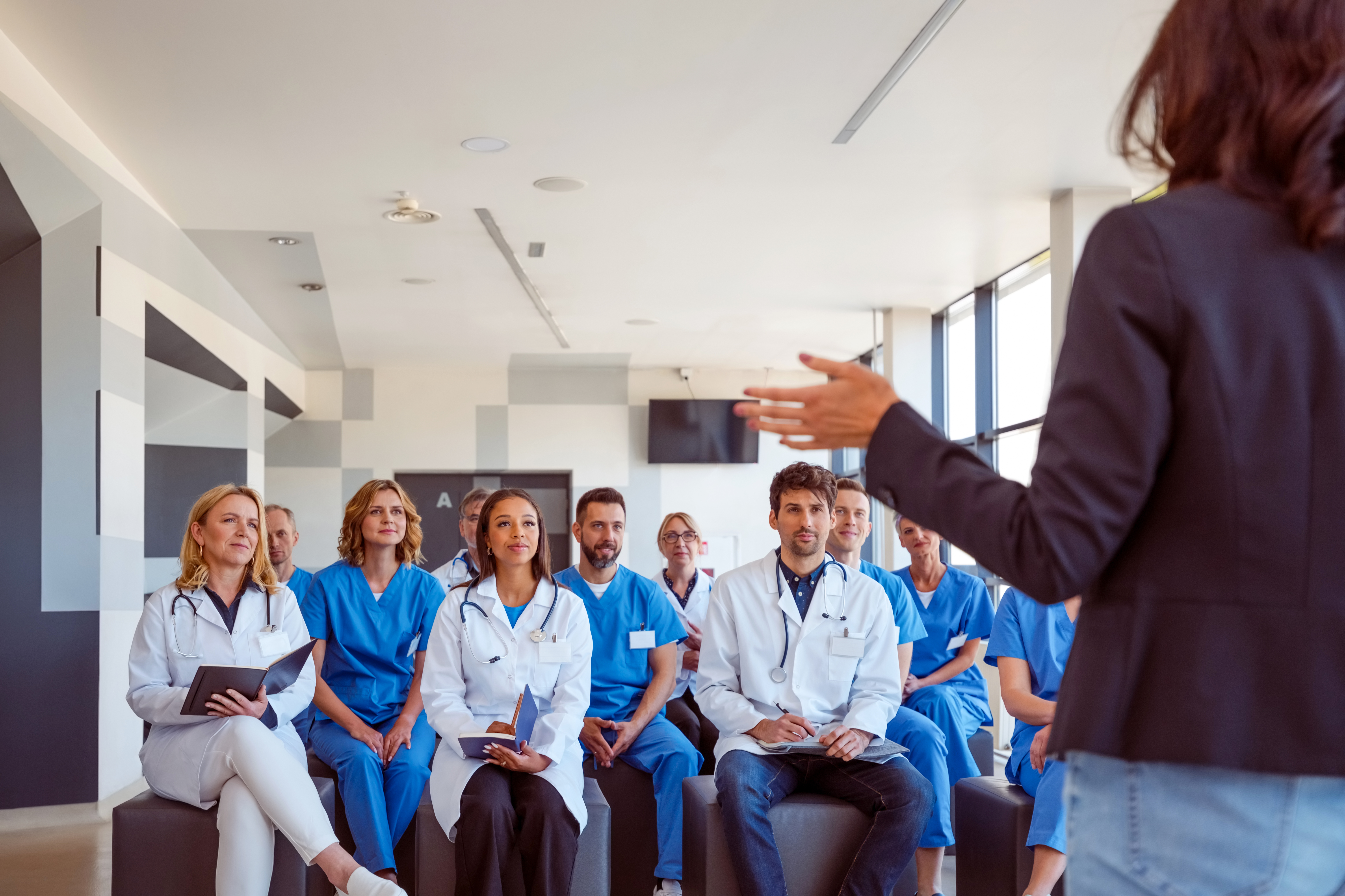 Une femme parlant devant un groupe de médecins et d’infirmières