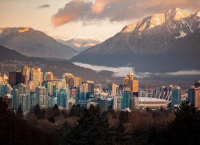 An evening landscape shot of the city of Vancouver with mountains in the background.