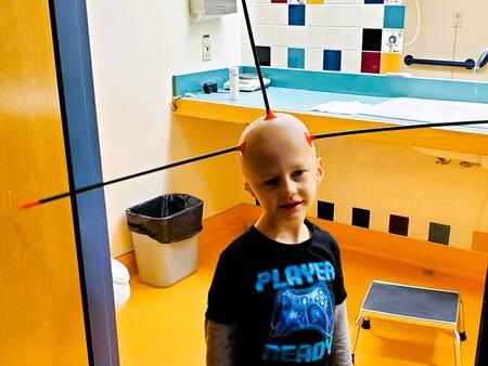 Theo so bald that arrows stick to his head during pediatric blood cancer treatment